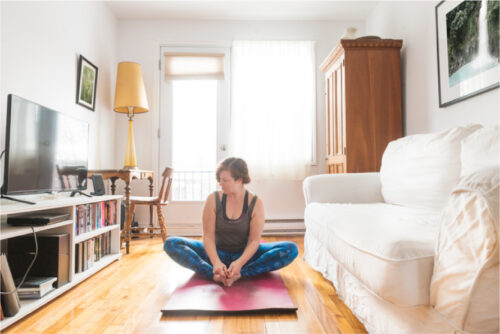 Woman on yoga mat in living room