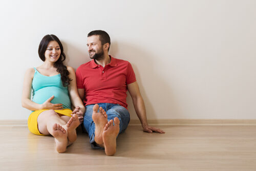 Pregnant couple sitting on the floor