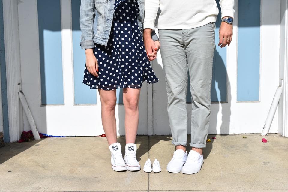 Couple holding baby shoes