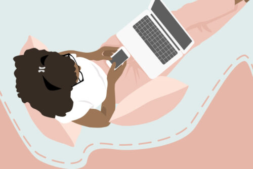 Woman texting on her phone while also working on her laptop, looking for ways to manage pandemic stress.