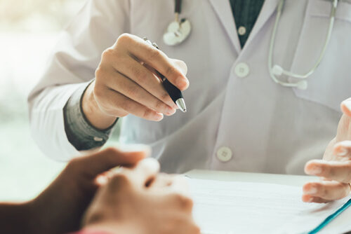 Doctor at their desk talking to a patient about herd immunity.