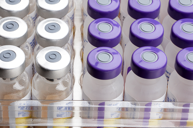 A case of various vaccines with labels on them explaining how they work.