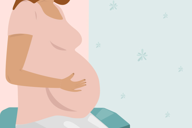 A pregnant person touching their stomach to represent pregnancy during COVID-19.