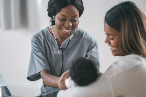 Mother with baby in her arms faces towards a smiling provider
