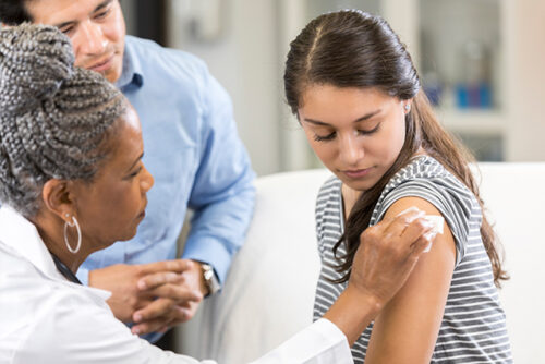 A doctor giving a patient a flu shot.