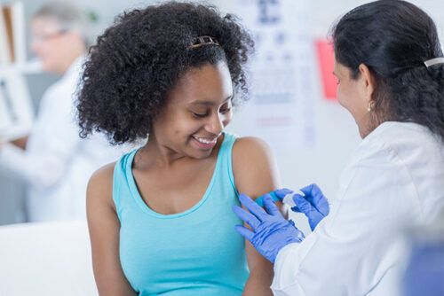 Woman getting the flu vaccine from her doctor.