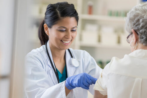 Doctor giving a patient a vaccine while informing her about common vaccine myths.
