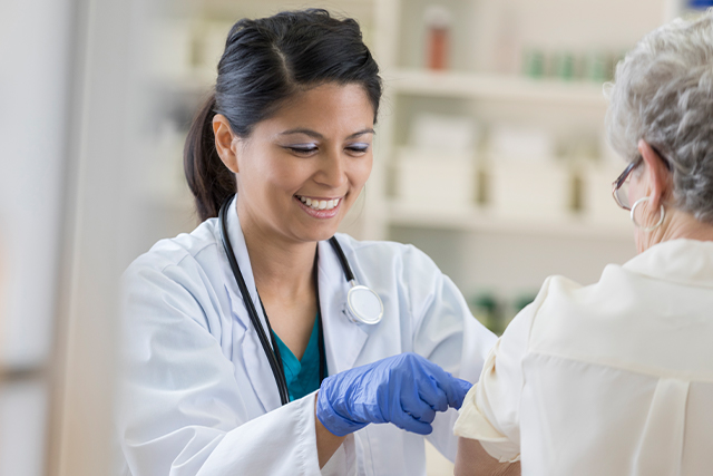 Doctor giving a patient a vaccine while informing her about common vaccine myths.