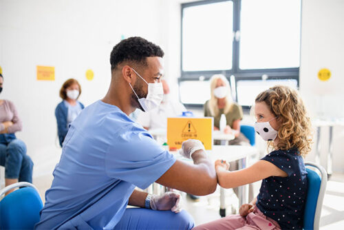Child and healthcare professional elbow bump