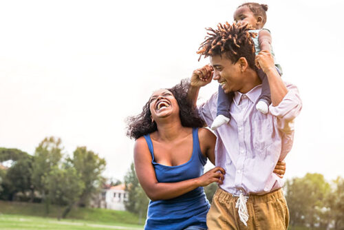 happy couple outside with child