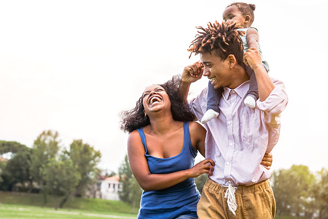 happy couple outside with child