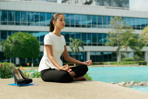 A person sitting cross-legged practicing a breathing meditation.