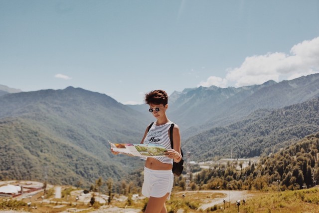 A person traveling checking their map to represent the question: 'how does travel affect ovulation?'