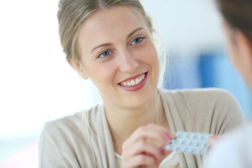 A person holding a pack of birth control pills and wondering about how it may affect fertility.