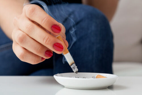 A person putting out their cigarette and wondering how smoking may affect fertility.