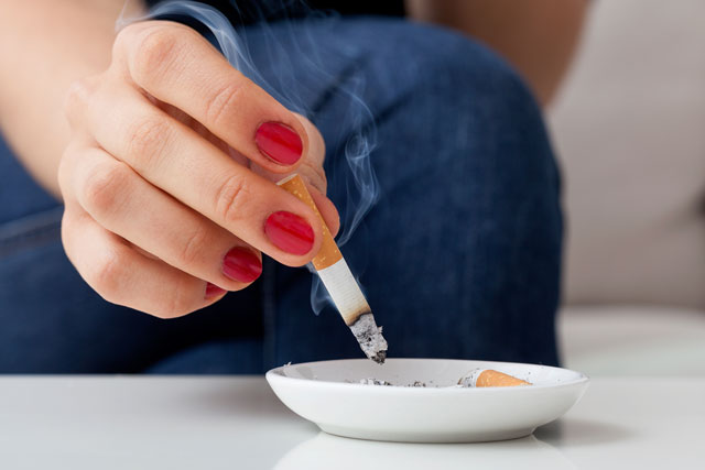 A person putting out their cigarette and wondering how smoking may affect fertility.