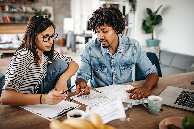 A couple working on finances to represent costs of having a baby