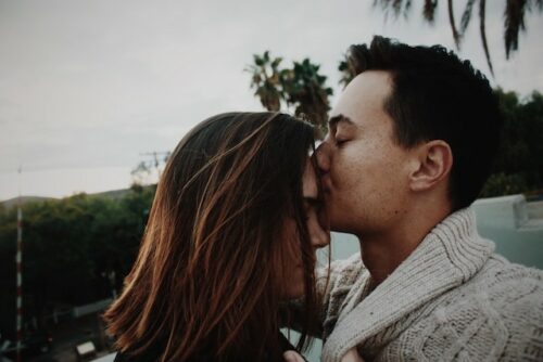 A couple and one is kissing the other on the forehead to people that have been trying to get pregnant for over a year.