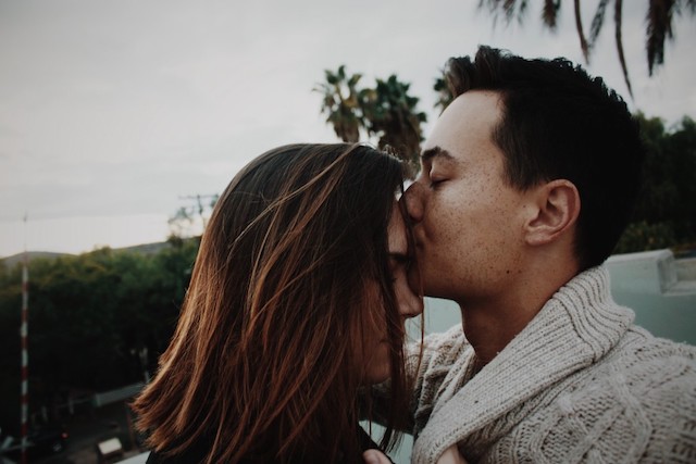 A couple and one is kissing the other on the forehead to people that have been trying to get pregnant for over a year.