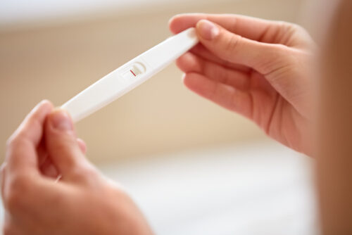 A person looking at their negative pregnancy test that is potentially a false negative.