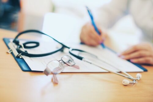 A fertility specialist writing on a piece of paper.