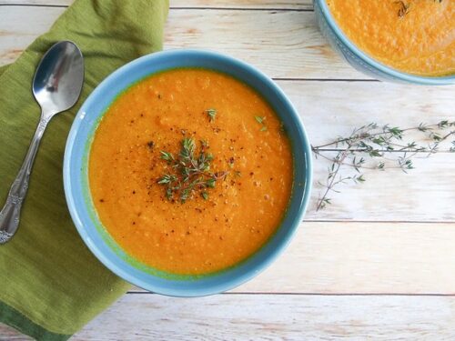 A blue bowl of roasted carrot soup.