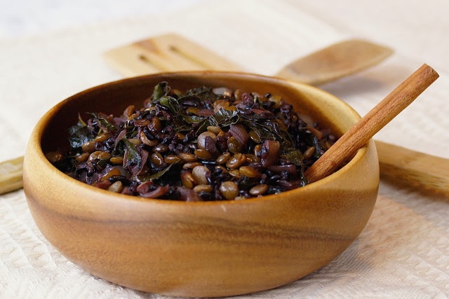 A bowl of lentils and kale with black rice and spices.