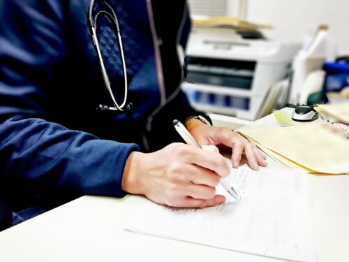 A patient coordinator writing down something on a piece of paper.
