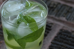 A mint, limeade mocktail in a clear glass with ice in it.