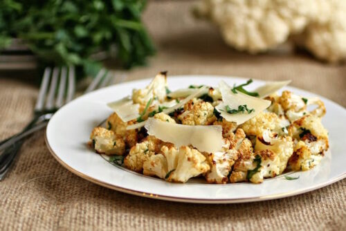 A plate of roasted cauliflower salad next to a fork.