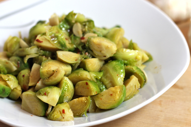 A plate of stir fry brussel sprouts with garlic.