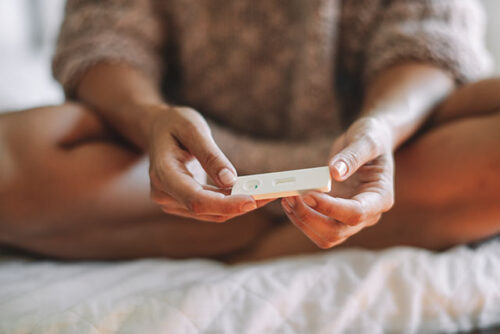 A woman holding a pregnancy test