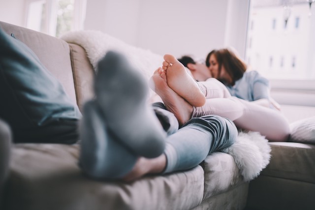 A couple laying together on the couch.
