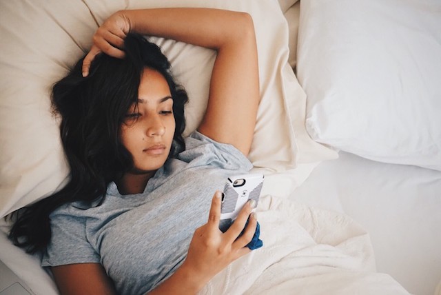 A person looking at her phone, using the Ovia Health ovulation tracker to determine fertile cervical position.