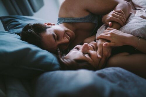A couple laying in bed.