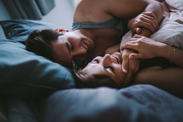 A couple laying in bed.