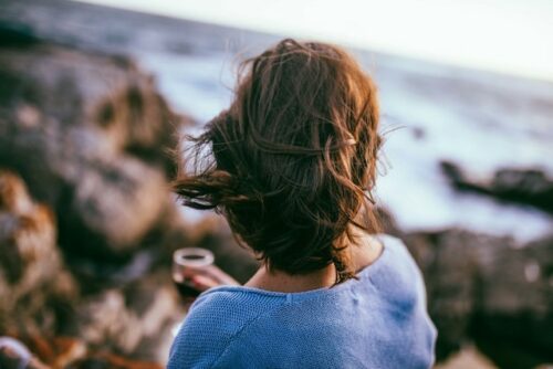 A person sitting by the ocean.