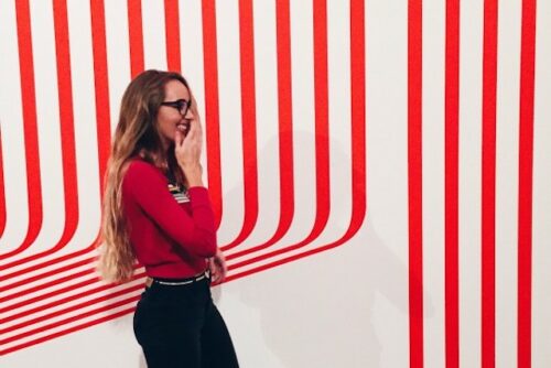 A person laughing in a red and white stripped room.