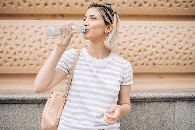 A woman drinking water.