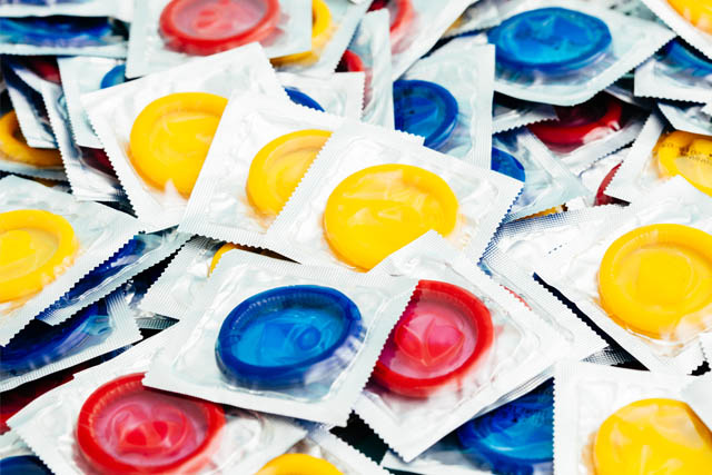 A pile of different colored condoms.
