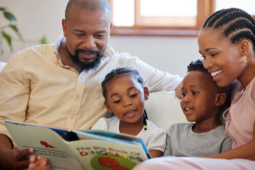 parents reading to their two children,