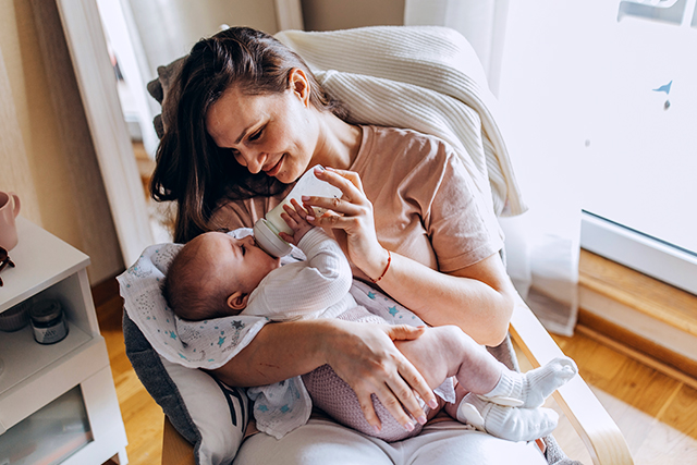 woman bottle feeds baby