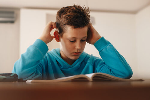 Child sits at a table with an opened book
