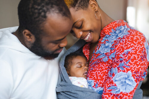 man and woman cradle a baby