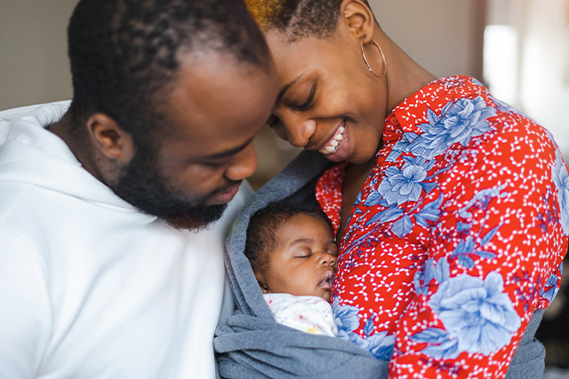 man and woman cradle a baby