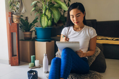 woman siting on floor writing