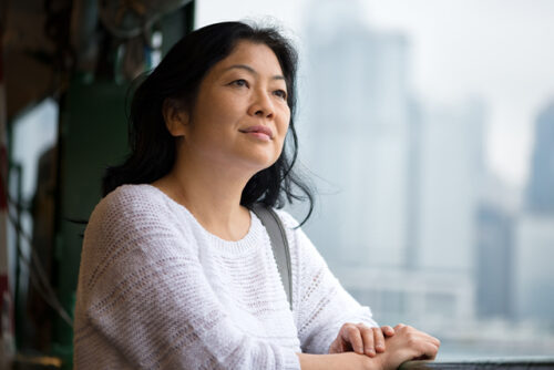 Woman looks contemplatively out the window.