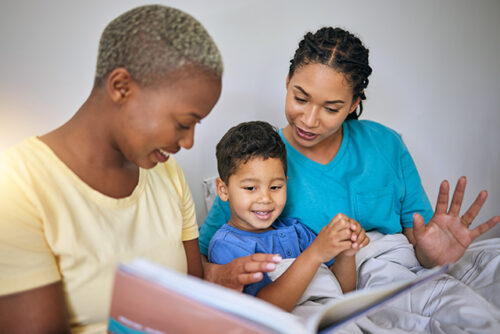 two women read to a boy
