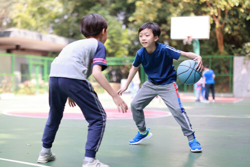Two boys playing basketball