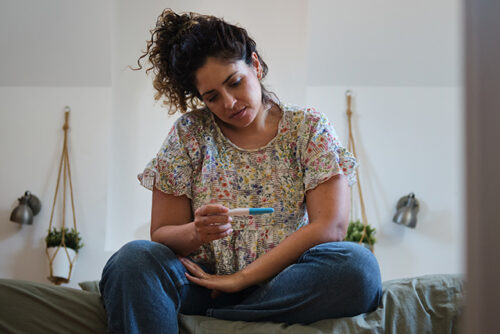 women looks at pregnancy test